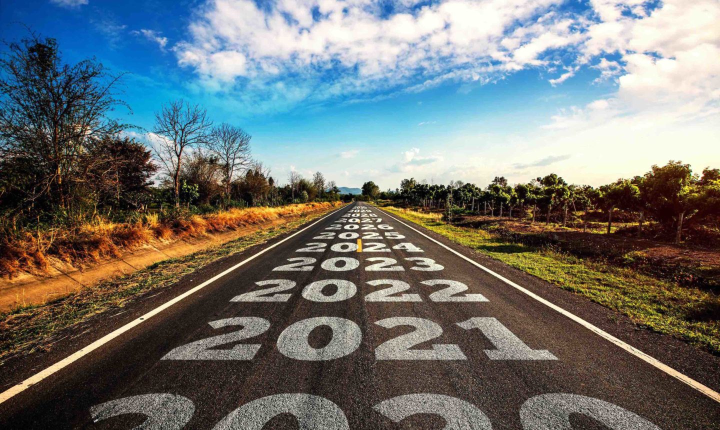 2020-2030 written on highway road in the middle of empty asphalt road and beautiful blue sky.