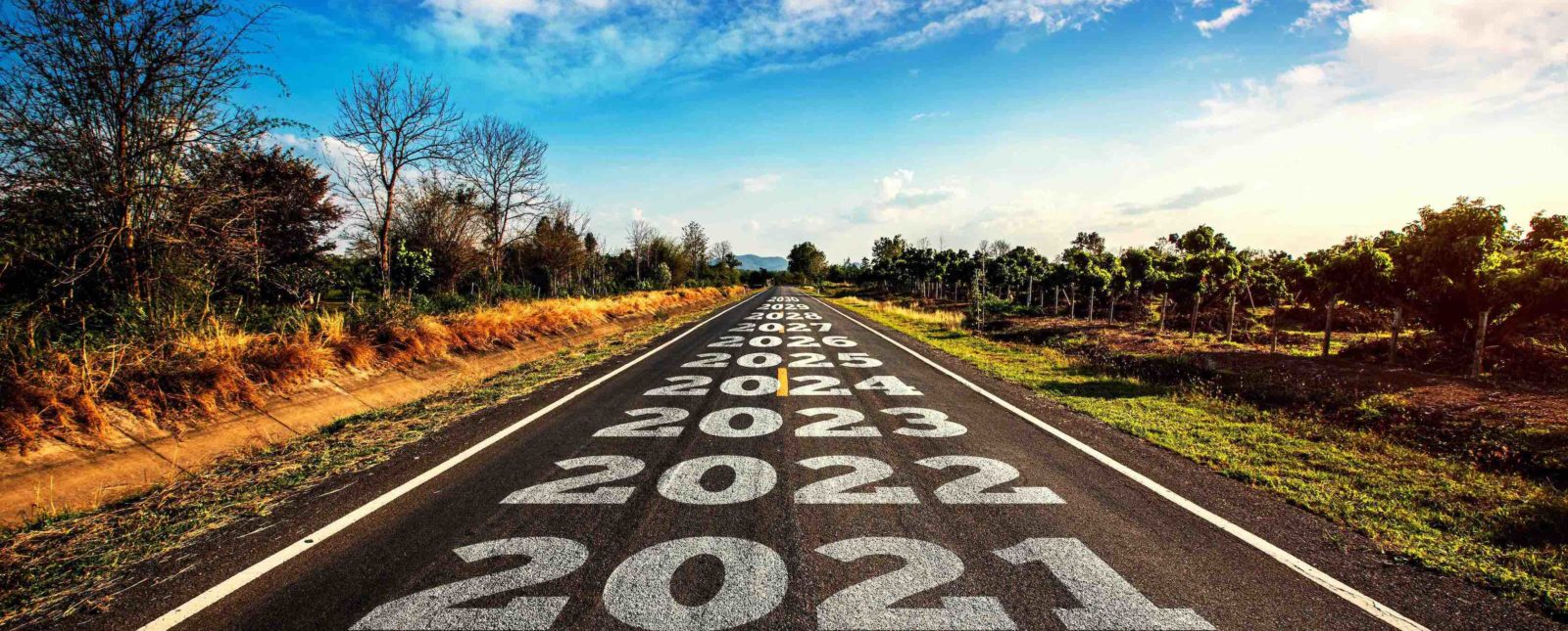 2020-2030 written on highway road in the middle of empty asphalt road and beautiful blue sky.