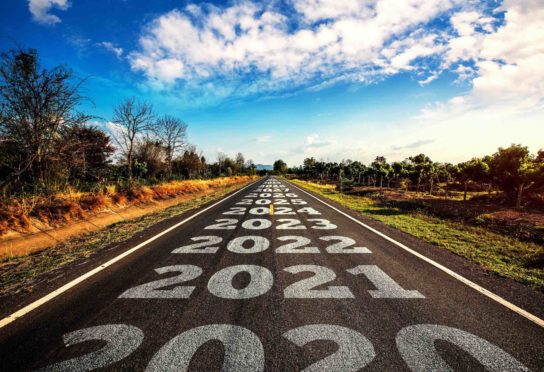 2020-2030 written on highway road in the middle of empty asphalt road and beautiful blue sky.