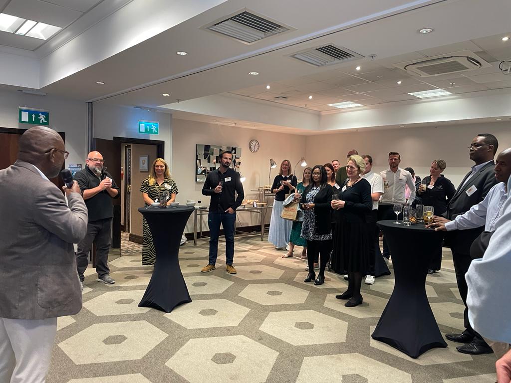 A group of people standing around at what appears to be some sort of cocktail party or happy hour.