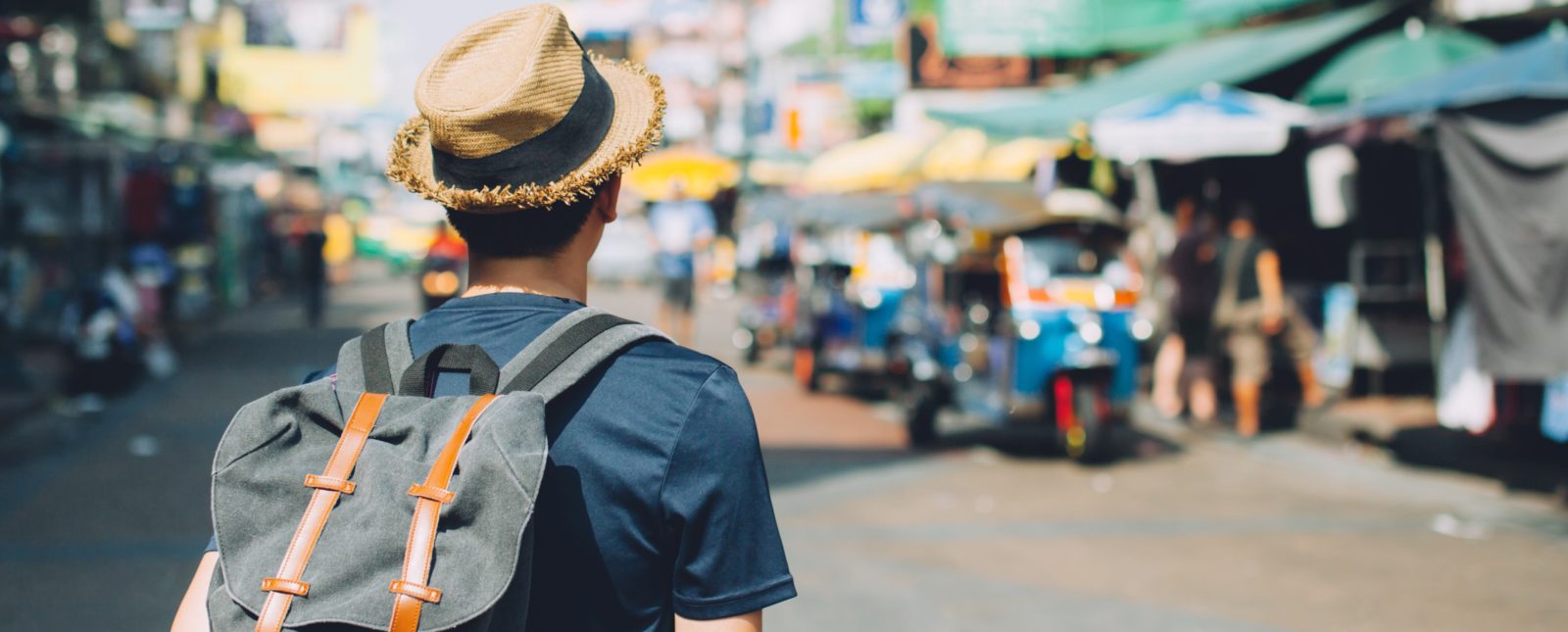 Young Asian traveling backpacker in Khaosan Road outdoor market in Bangkok, Thailand