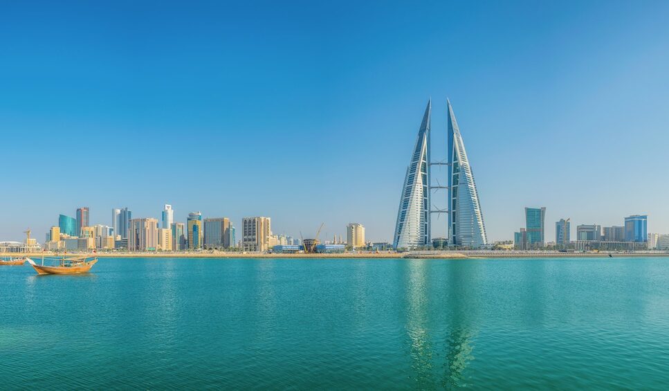 Skyline of Manama dominated by the World trade Center building, Bahrain. Blue water in front