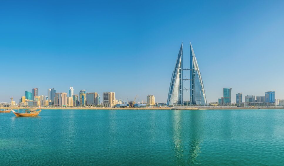 Skyline of Manama dominated by the World trade Center building, Bahrain. Blue water in front