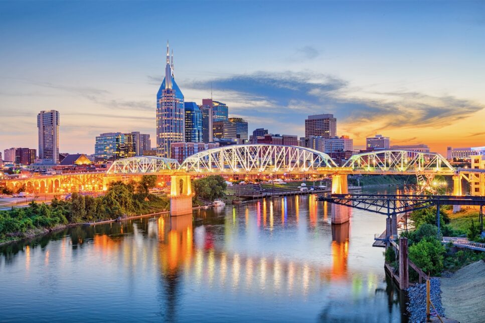 Downtown Nashville view of building and bride on the water at night